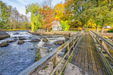 Pedestrian bridge over Morrum river in autumn scenery