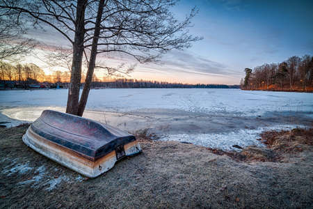 Morning winter landscape with rowboatの写真素材