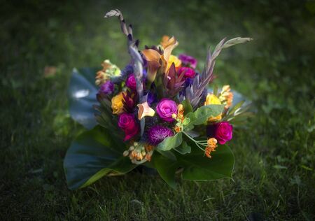 Bouquet of roses, gladioli and calla on grass in summerの写真素材