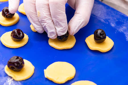 Placing Amarena Cherry On Marzipan Circles For Christmas Cookiesの写真素材