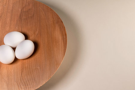 Three Eggs In A Wooden Bowl On A White Tableの写真素材