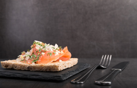 smoked salmon on toast with onion and parsleyの写真素材