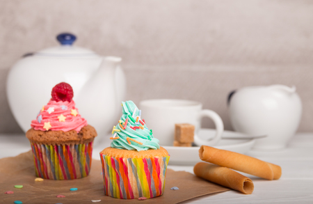 home baked cupcakes with colorful frosting and fruit with coffeeの写真素材