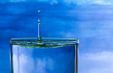 water drop splash in a glass of drinking waterの写真素材