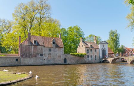 Bruges, Belgium - Mai 4, 2018: View on the Dijver river with the medieval beguinage on the backgroundのeditorial素材