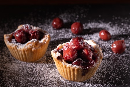 Homemade cherry pie in a spot light on a dark background