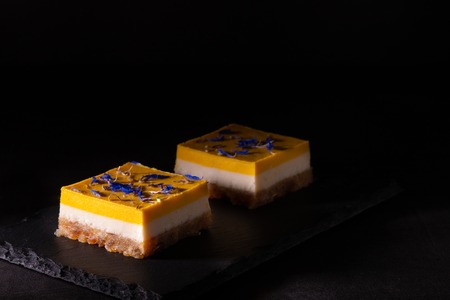 Homemade lime and mango cake on a black stone plate