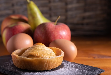 Fresh homemade apple pie on a black slate with fruit