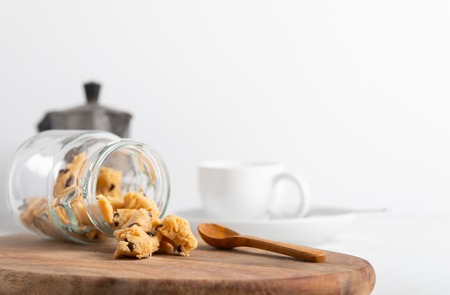 A serving of homemade cookie dough on a wooden table, with a wooden spoon.の写真素材