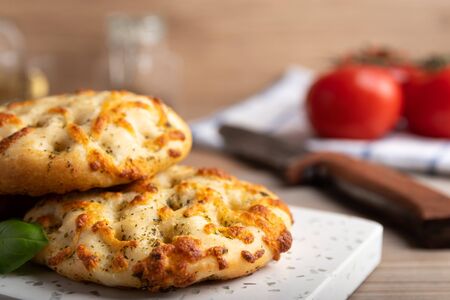 Home baked Italian Focaccia bread with mozzarella and herbs on a plate.の写真素材