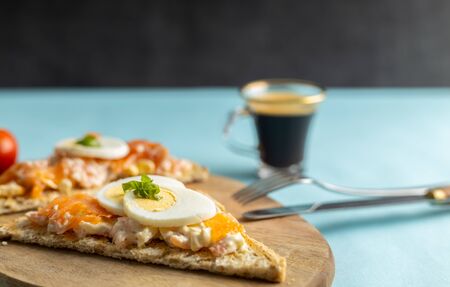 A delicious smoked salmon spread made of yogurt and spices on a whole grain bread toast with a cup of coffee on the side.の写真素材