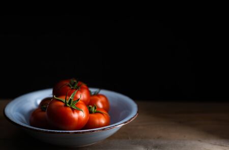 Fresh fruit, delicious tomato on a dark background with copy space.の写真素材