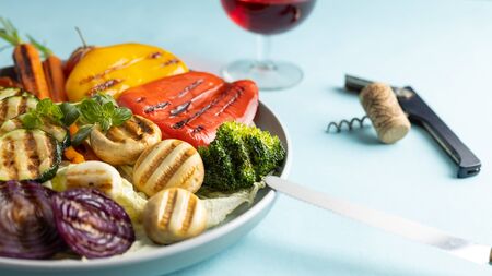 Organic grilled vegetables bell pepper, cauliflower,broccoli,carrots,mushrooms and red onions served on a round plate. Vegetarian dinner serving of roasted vegetables.の写真素材