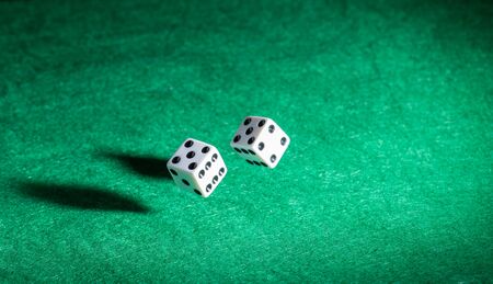 Playing casino games dice throw on a green table.の写真素材