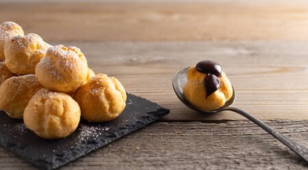 Delicious profiteroles, cream puff filled with fresh cream with chocolate topping.