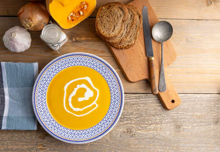 Fresh homemade butternut soup on a kitchen table.の写真素材