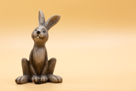 Figure of an Easter bunny in front of yellow green background with copy space for free text to Easter for invitations or cards. Horizontalの写真素材