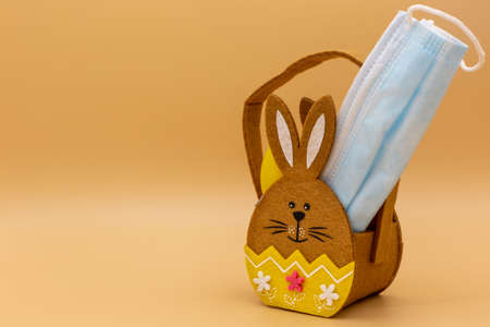 Easter with eggs, gift bag and medical masks in times of covid 19, corona and families with contact ban. Horizontalの写真素材