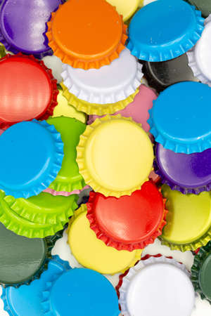 Close-up of crown corks in different colors like blue, green, yellow and red lying on top of each other as backgroundの写真素材