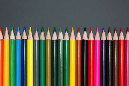 large set of crayons lined up in different colors with dark background for school and arts with copy space for free textの写真素材