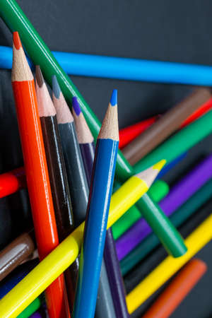 Colored pencils in close-up as background or for school and arts placed on top of each other in blue, yellow and redの写真素材