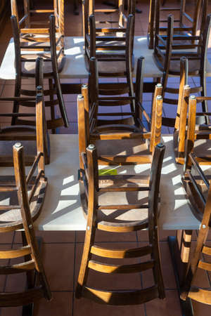 virus and closed restaurant with chairs on tables because of lockdown or shutdown in germany 2021