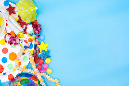 Utensils for children's birthdayparties and parties such as smarties, umbrellas and mugs on a blue background. Horizontalの写真素材
