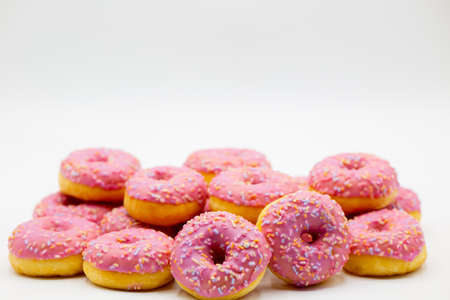Group of pink donuts against a white background with copy space above. Horizontalの写真素材