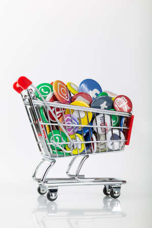 Shopping cart with social media logos from facebook, instagram, youtube and whatsapp symbolizes the business with users. Vertical formatのeditorial素材