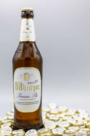Beer bottle and caps from the brewing company Bitburger, photographed on 02.01.2021 in bad Homburg, Germany, with gray background and copy space. Verticalのeditorial素材