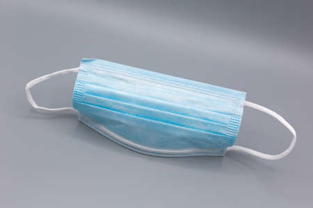 single medical mask in times of  pandemie on gray background. horizontalの写真素材