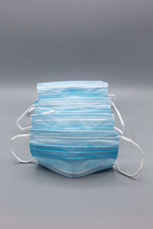 Several blue medical face masks   on gray background. Vertical photo
