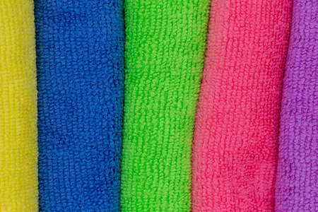 Towels and cleaning cloths in different colors as background to the theme household, showers and...