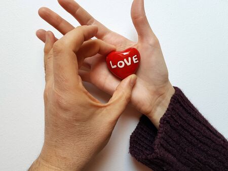 Two hands, one is leaving an heart in the other one.の写真素材