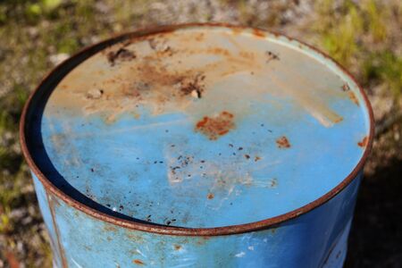 a blue rusty oil barrel in nature