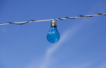 blue light bulb with blue summer sky