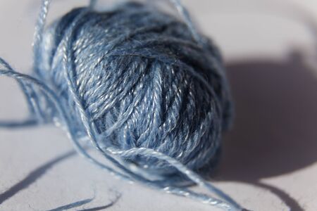 a light blue yarn seam with cotton thread on light simple background at Umedalenの写真素材