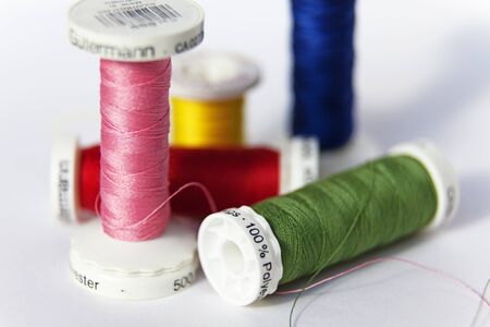 Umea, Sweden - August 15, 2019: sewing thread on reel in different colors on white backgroundのeditorial素材