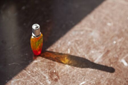 perfume bottle that the sun shines through and colors the shadow that falls on the tableの写真素材