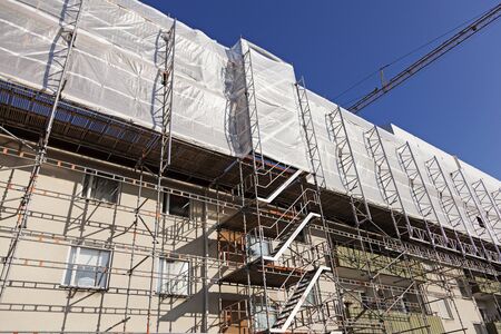 Umea, Sweden - August 14, 2019: renovation of existing house on Hedlunda with extension of additional floors. A lot of scaffolding has been installed and in the background we see a lifting crane.のeditorial素材