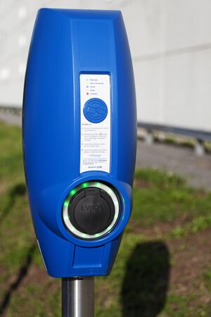 Umea, Sweden - July 27, 2019: blue pole to charge electric cars with outside Volvoのeditorial素材