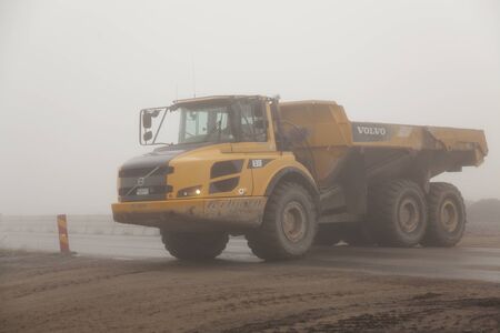 Umea, Sweden - August 23, 2019: work vehicles transport land for new road project in the fog at Robackのeditorial素材