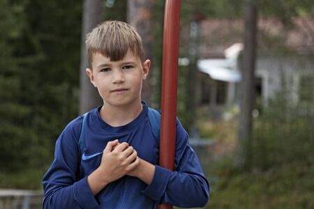 Umea, Sweden - June 26, 2019: a little serious guy holds his hands to his heart at the playground in Robackのeditorial素材