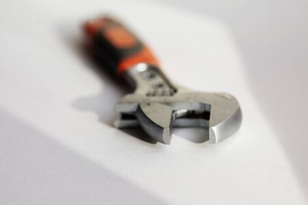 the top of a wrench is in sharpness, it is on a white background with sunlight coming in from the windowの写真素材