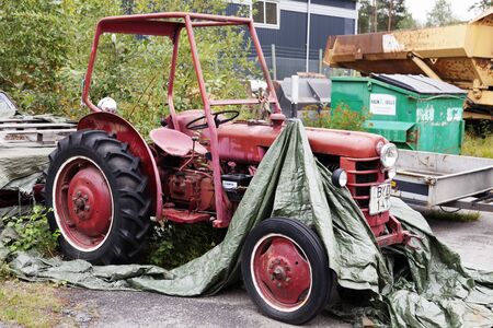 Umea, Sweden - August 26, 2019: an old red open and worn tractor, where the tarpaulin blown offのeditorial素材