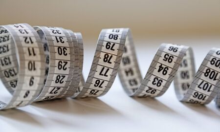 a white tape measure lying in a tangled spiral on the table