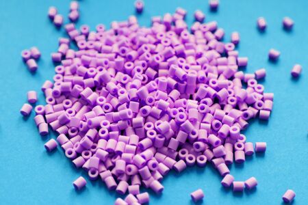 purple beads on blue background, toy for children who want to make necklaces