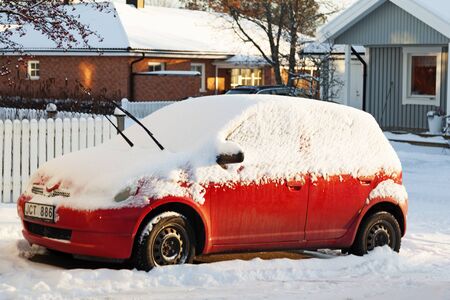 Umea, Norrland Sweden - December 5, 2019: a red snowed car stands in the parking lotのeditorial素材