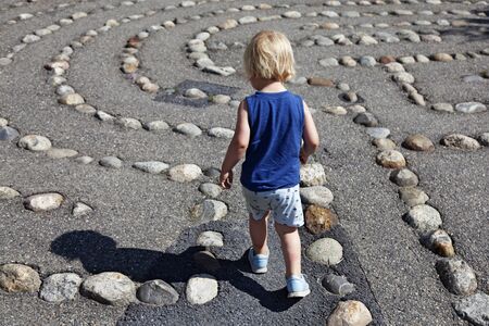 Umea, Norrland Sweden - June 12, 2019: a little guy walks in a maze made of stonesのeditorial素材