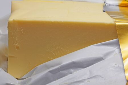 A whole package of butter lying in gold foilの写真素材